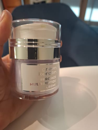 Client tenant le pot de crème PRO:AGE MULTI-PEPTIDE dans sa main, montrant l'emballage.