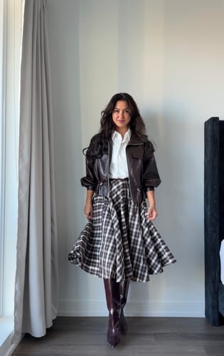 Reviewer standing indoors wearing the dark Faux Leather Drawstring Bomber Jacket, showing its baggy fit.