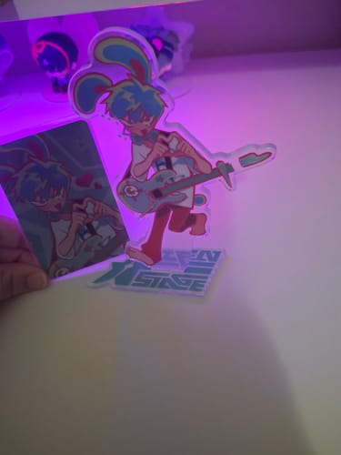 Reviewer holding the photocard next to the assembled Alien Stage Rabbit Series acrylic standee on a desk.
