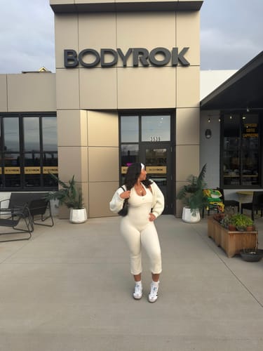 Customer standing outside in the cream Perfect Capri and a matching top, seen from the side.