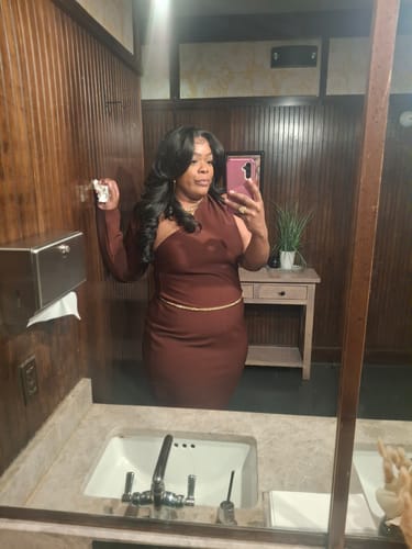 Reviewer in a mirror selfie wearing the long, wavy Sensationnel Bare Lace Glueless Wig.
