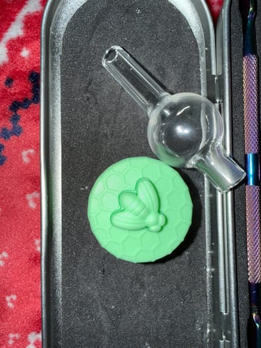Reviewer's bubble carb cap and green silicone stash jar inside the Smoke Box kit case.