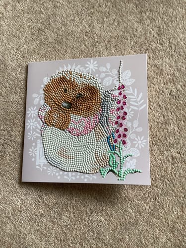 Reviewer's completed Mrs. Tiggy-Winkle Crystal Art Card showing the sparkling hedgehog design on a carpet.