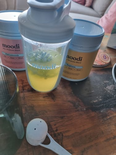 Customer's Original Pre + Probiotic Bundle tubs with the drink being mixed inside a clear shaker.