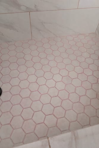 Customer's dirty shower floor with pink grout before using the Bathroom Concentrate.