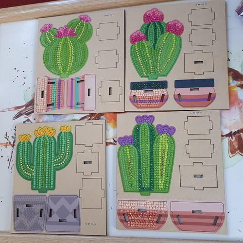 Customer's in-progress Crystal Art Cacti, with four decorated cactus templates on their punch-out boards.
