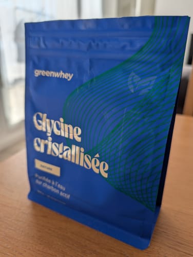 Sachet de Glycine cristallisée du client, de couleur bleue, posé sur une table en bois.