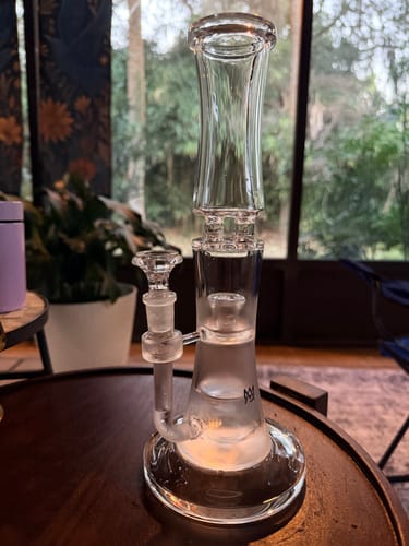 Customer's clean MJ Arsenal Spire Glass Water Pipe sitting on a wooden table, showing its thick base.