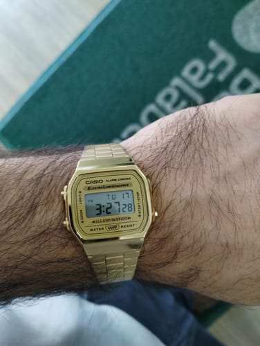 Primer plano del reloj Casio Vintage dorado en la muñeca de un cliente.