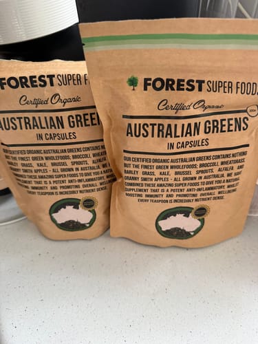 Reviewer's two large bags of Australian Greens Whole Food Capsules sitting on a kitchen counter.