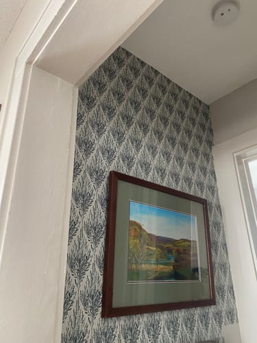 Customer's Beatrix Wallpaper with a dark botanical print applied in a vestibule corner with a painting.