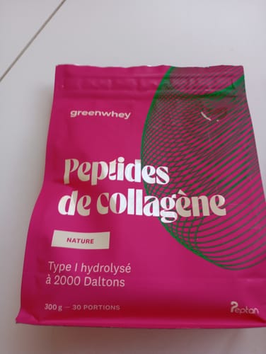 Un client montre le sachet rose de Peptides de Collagène saveur Nature sur une surface blanche.