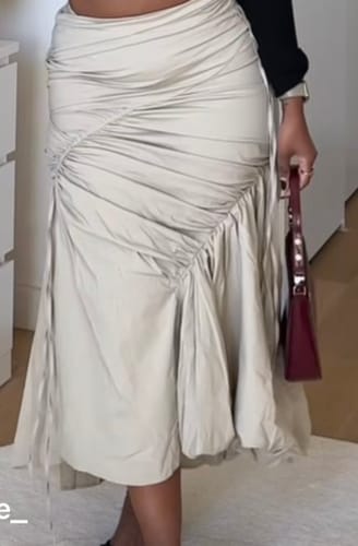 Customer wearing the light-colored Ruffle Midi Fishtail Skirt, showing the ruched detail and flared hem.