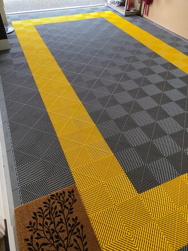 Customer's garage with newly installed Modular Interlocking Garage Flooring in a stylish grey and yellow rectangular pattern.