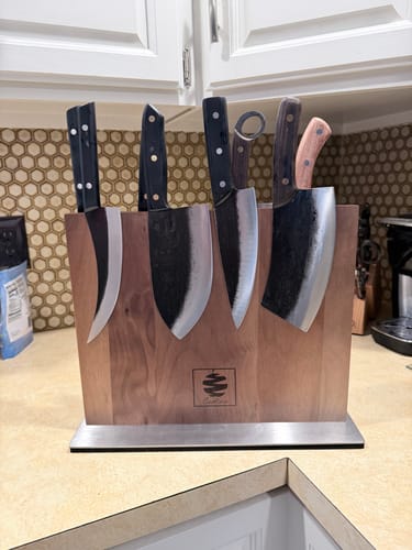 Customer's set of assorted knives displayed in a handsome wooden magnetic block on a kitchen counter.