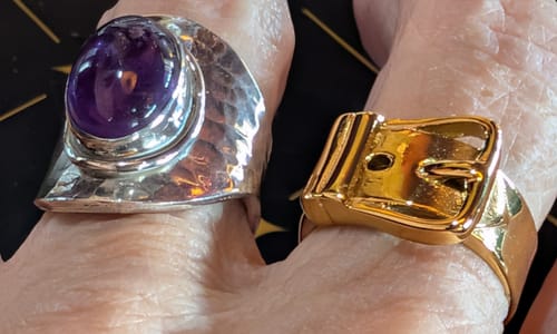 Cliente portant la Bague Argent Améthyste à côté d'une autre bague, montrant la pierre violette et la bande martelée.