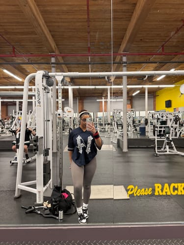 Reviewer takes a mirror selfie at the gym wearing the oversized dark W488 XIV Jersey.