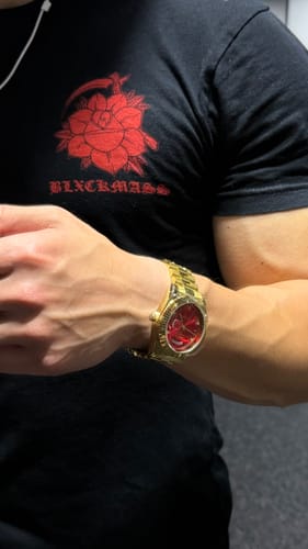 Reviewer wearing their gold Lucky Fours® Santos watch with a vibrant red dial on their wrist.