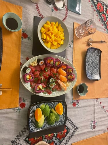 Kundenbild von gewürfelten Bio Kent Mangos in einer Schüssel als Teil einer Mahlzeit mit Sushi.