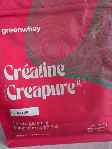 Client montrant un gros plan du sachet rose de Créatine Creapure®, saveur Nature.