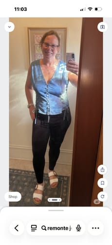 Reviewer taking a mirror selfie wearing the blue patterned Women's Lace Up Vest, showing the side ties.