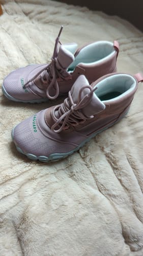 Reviewer's stylish pink Will I Lite - Barefoot Shoes resting on a fluffy beige surface.