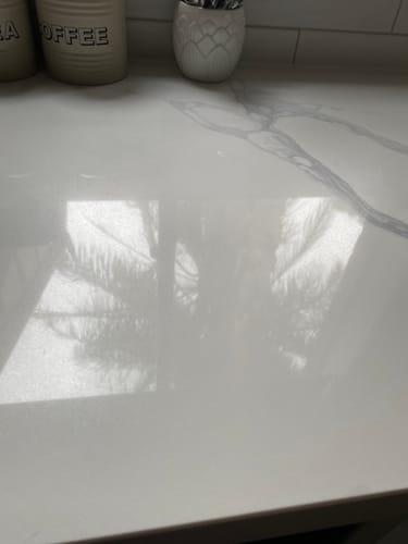 Customer shows a shiny, reflective stone benchtop after being polished with a KoalaCloth.