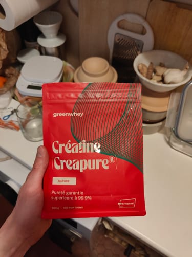 Client tenant dans sa main le sachet rouge de Créatine Creapure®.