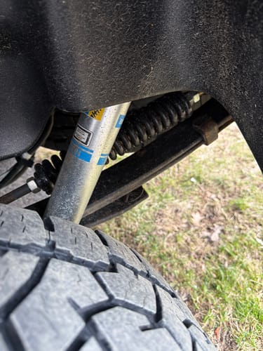 Customer's close-up of the HD Kit installed, showing the black coil spring and a new shock absorber in a Ford F-150 wheel well.