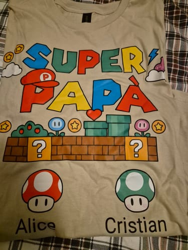 Rezensent zeigt das personalisierte 'Super Papà' T-Shirt mit Videospiel-Motiv und den Namen Alice und Cristian.