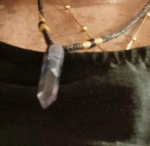 Close-up: A reviewer wearing the Natural Fluorite Necklace with its purple crystal pendant against their chest.