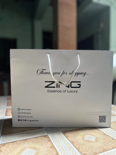 Customer's white shopping bag for their Bleu De Zing perfume, showing the brand logo.