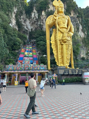 Reviewer wearing the olive green SIV bag crossbody while traveling at an outdoor temple.