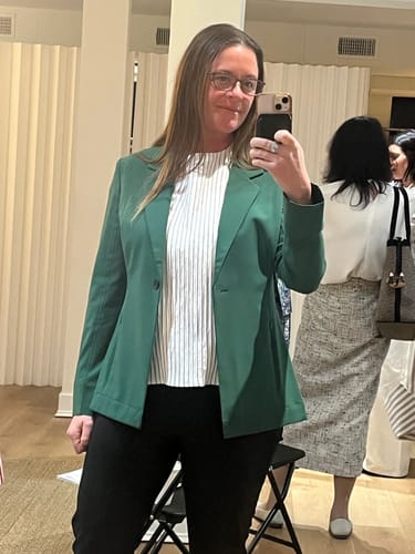 Reviewer wearing the striped Didion Drape Top under a viridian blazer in a mirror selfie.