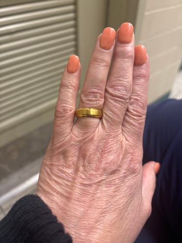 Reviewer's hand wearing the gold Tharos ring, highlighting its brushed finish and fit on the finger.