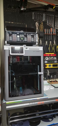 Customer's new 3D printer set up on a workbench in a workshop, which was covered by shipping protection.