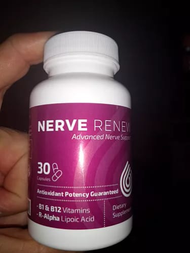Customer holding a white bottle of Nerve Renew supplement with a purple label.