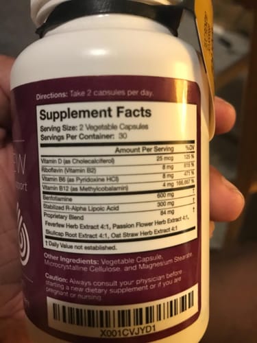 Reviewer holds the BioNerve+ Nerve Renew Complex bottle, showing the supplement facts label on the back.