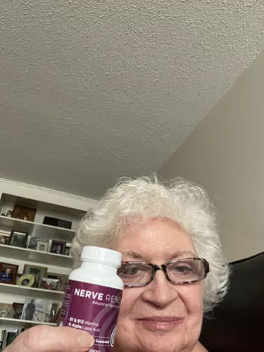 A smiling reviewer holds up a white bottle of BioNerve+ Nerve Renew Complex.
