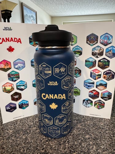 Customer's blue Canada Bottle with gold engraved destinations displayed in front of matching sticker sheets.