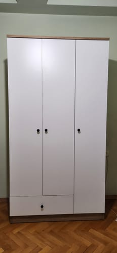 Yorumcunun odasına kurduğu, beyaz ve ceviz renkli üç kapaklı Rani gardırop.