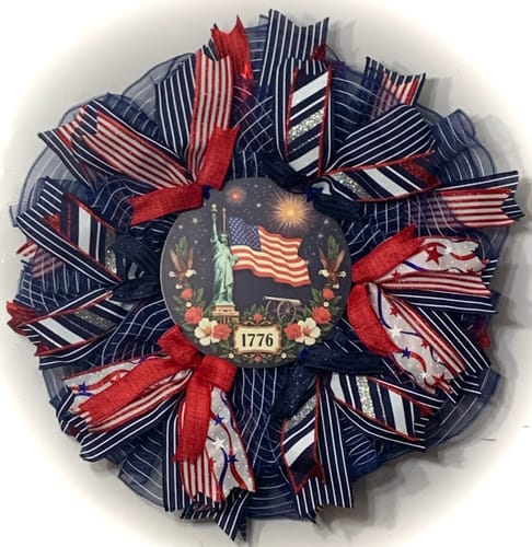 Customer's patriotic wreath made with the navy blue fine weave metallic mesh, decorated with ribbons.