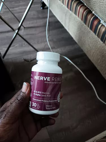 Reviewer's hand holding the white bottle of BioNerve+ Nerve Renew Complex.