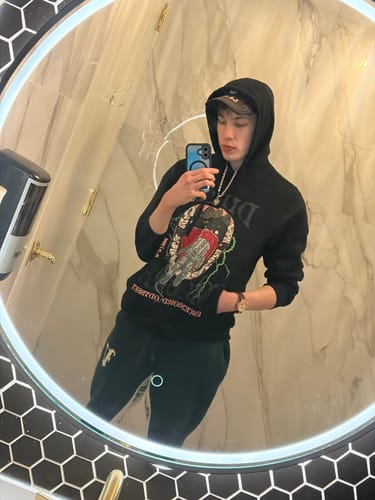 Reviewer's mirror selfie wearing the Antique Heart Pendant on a silver chain over a black hoodie.