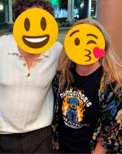 Reviewer wearing the black Pyrokinesis for Puppers Tee under a floral cardigan.