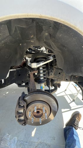 Reviewer's close-up of the newly installed Forged Aluminum Upper Control Arm in the truck's wheel well.