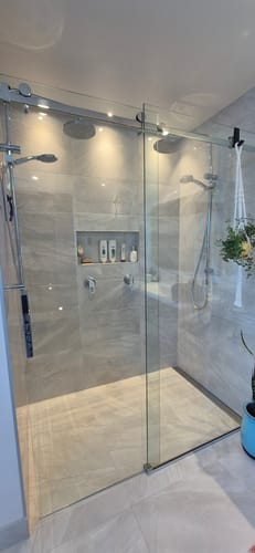 Customer shows their shower's sparkling, streak-free glass after cleaning with a KoalaCloth.