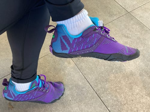Customer wearing the purple and blue Free Ⅰ - Barefoot Shoes with white socks and black leggings.