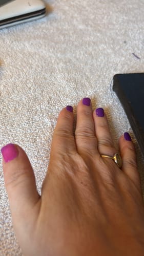 Customer's hand showing the color-changing gel polish, with a pink thumb and solid purple nails.