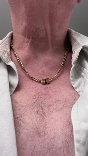 Close-up of a reviewer wearing the gold-colored Legacy necklace with two beads.